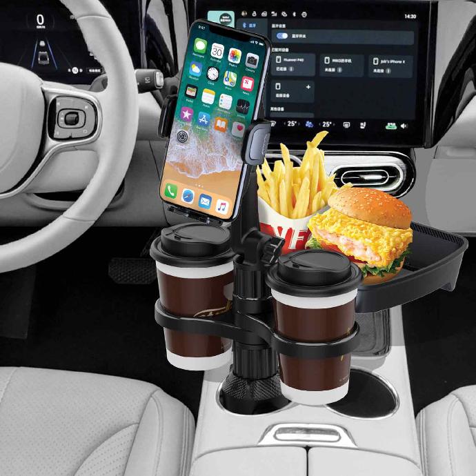 alt=" there is a car that inside it there is cup holder that burger and fries in it bwith two cup of coffee and phone with sea background 